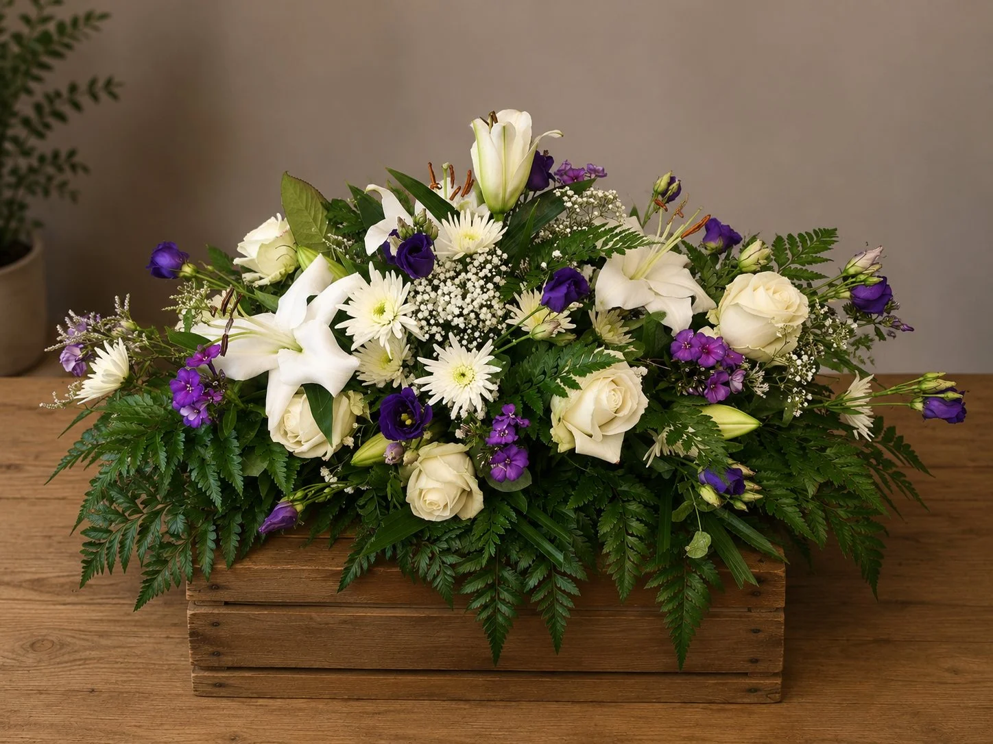 White lily, rose and lisianthus funeral tribute in a wooden crate by Quality Plants and Flowers, Denby Dale