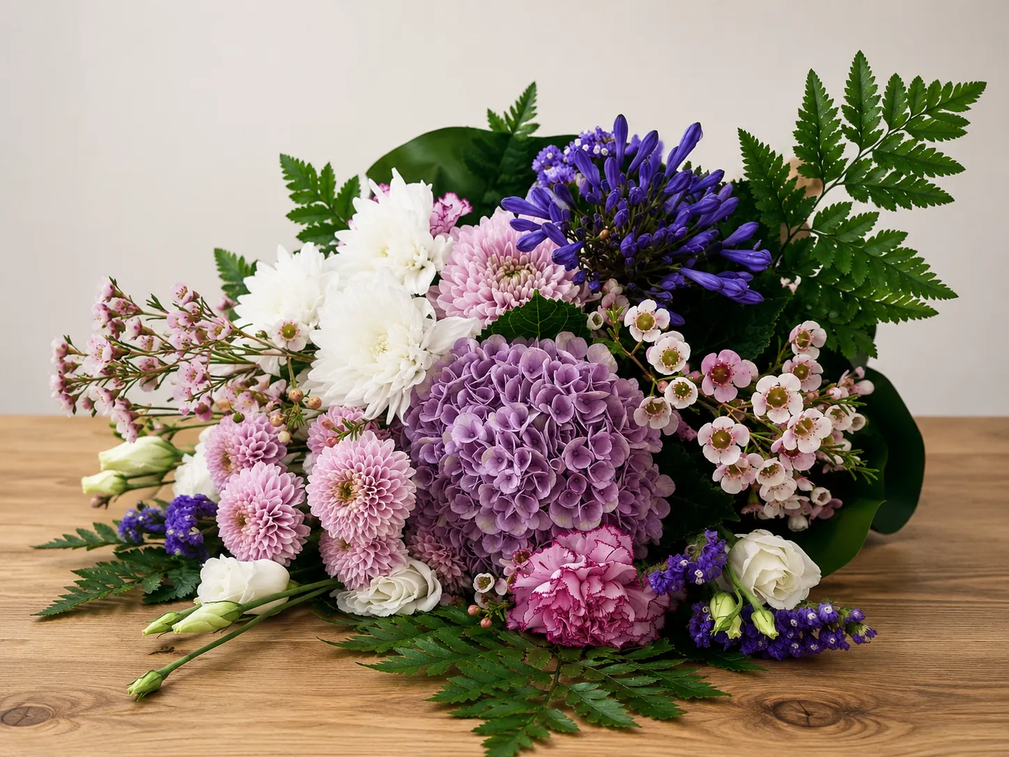 Hand-tied bouquet with purple hydrangea, agapanthus and pink chrysanthemums
