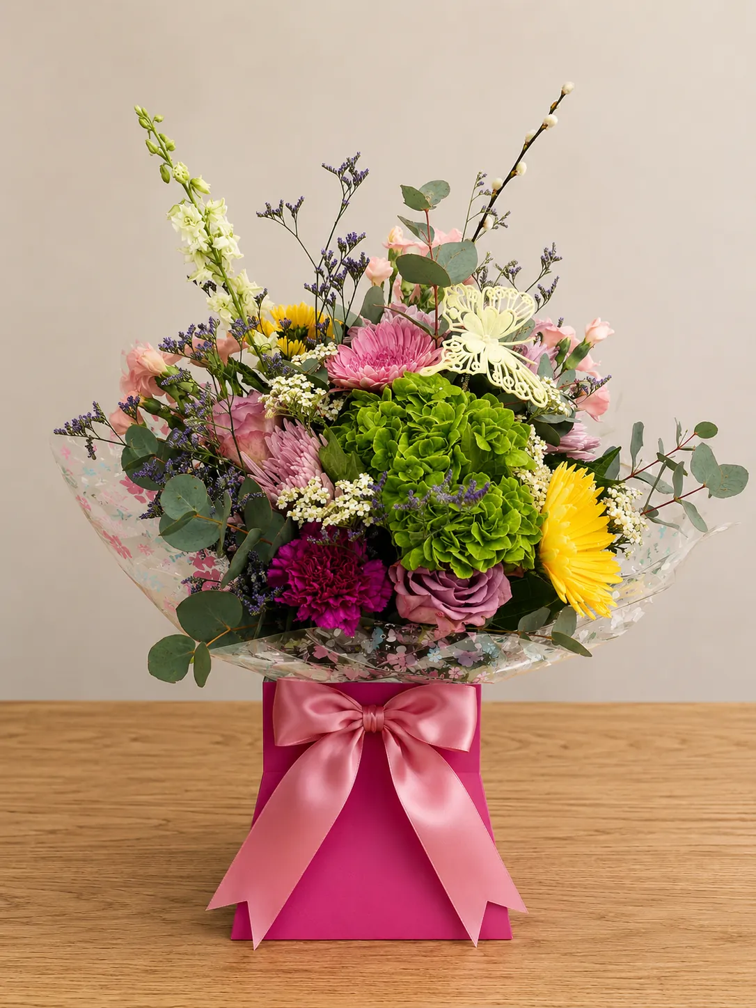 Pastel box arrangement with green hydrangea, yellow gerbera and a butterfly pick