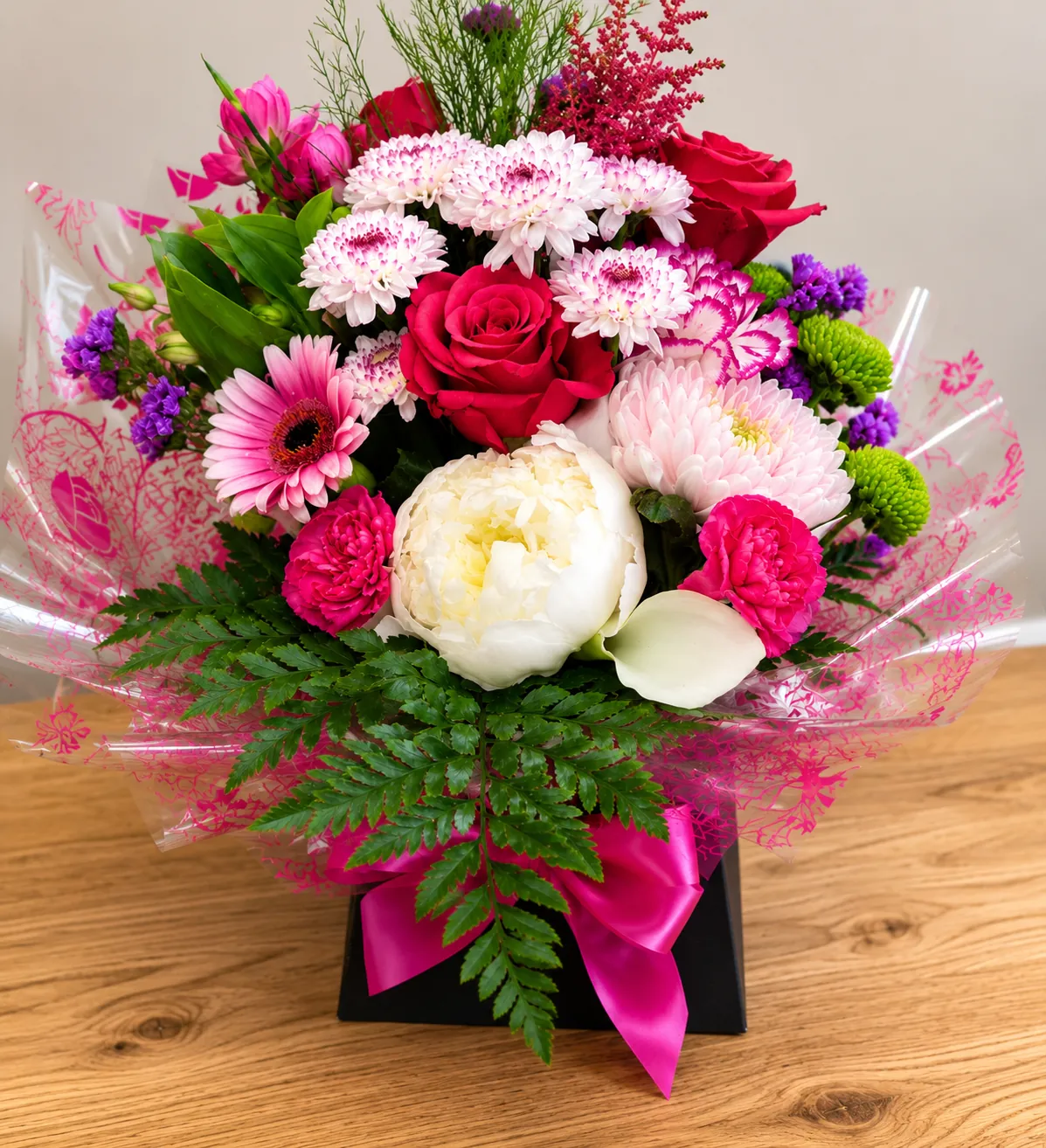Bright box arrangement with red roses and pink chrysanthemums