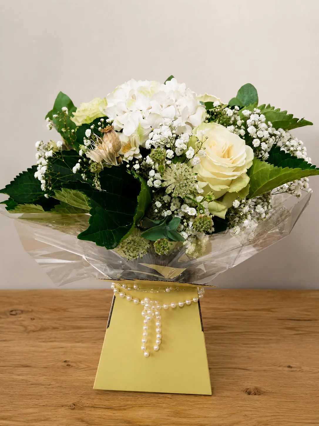 White rose and hydrangea box arrangement with gypsophila in a gold gift box with a pearl strand