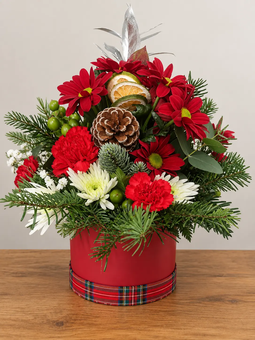 Christmas hat box flower arrangement with red roses and festive foliage