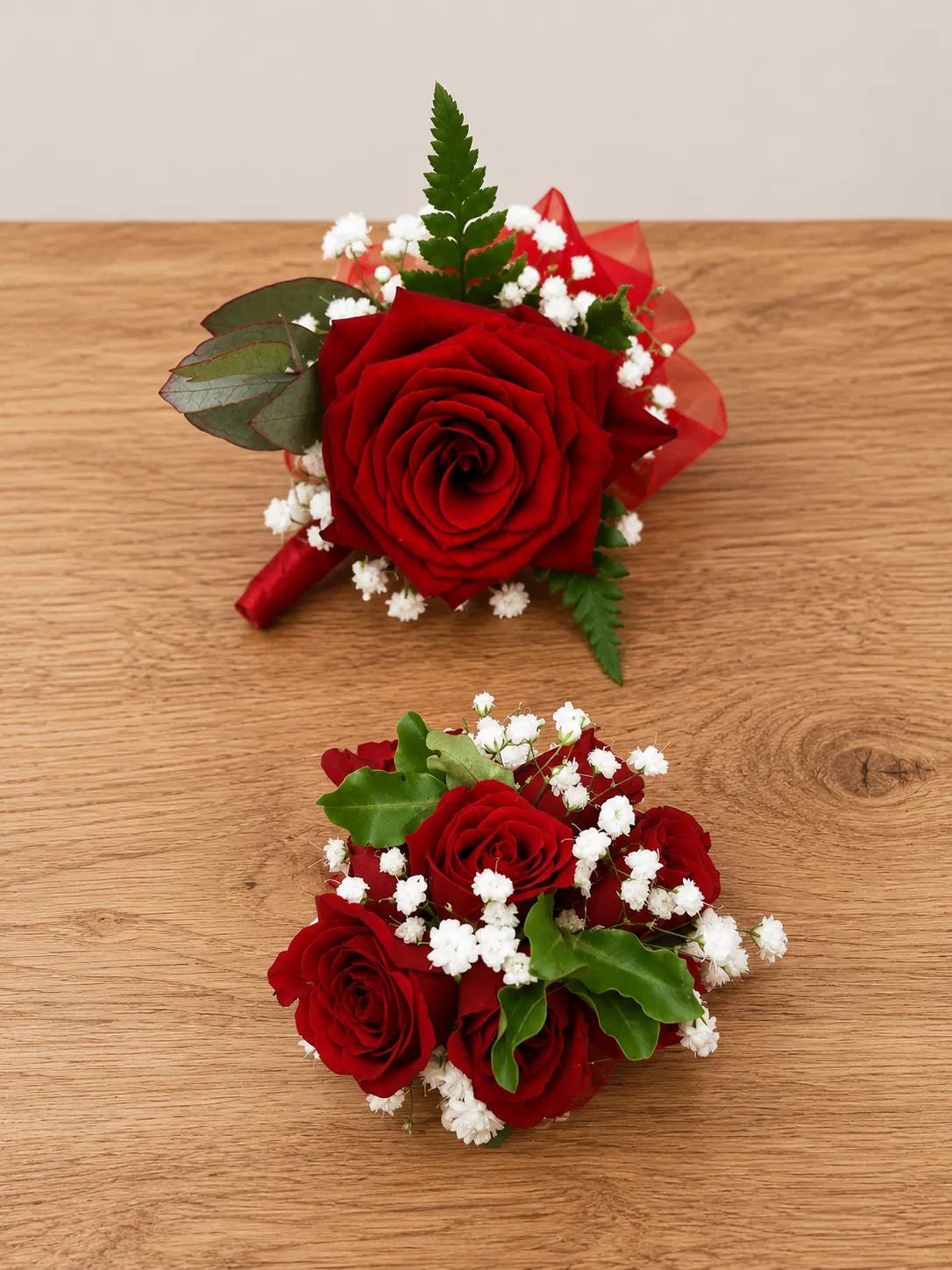 Single red rose buttonhole beside a matching bridesmaid posy
