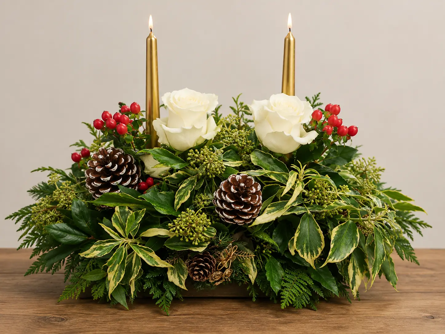 Christmas table centrepiece with white roses and festive foliage