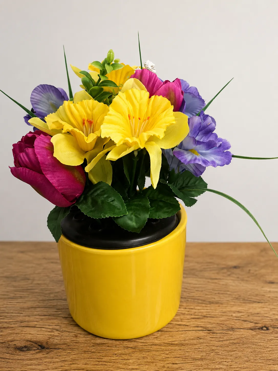 Colourful mixed flower plant in a yellow ceramic pot